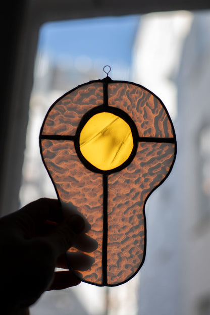 Decorative egg-shaped sun catcher held against a blurred background
