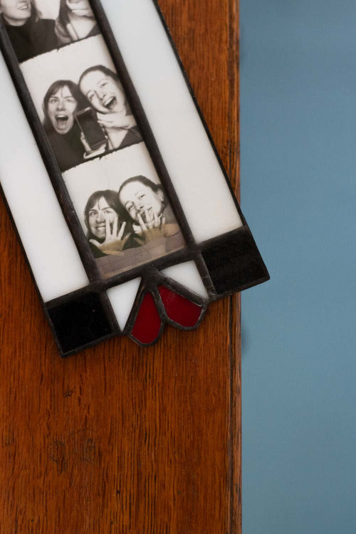 Strip of Polaroid photos with people's faces on a wooden surface.