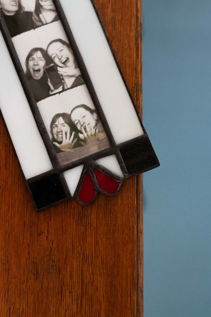 Strip of Polaroid photos with people's faces on a wooden surface.
