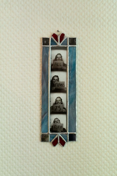 Decorative stained glass frame with four small portraits on a textured white background